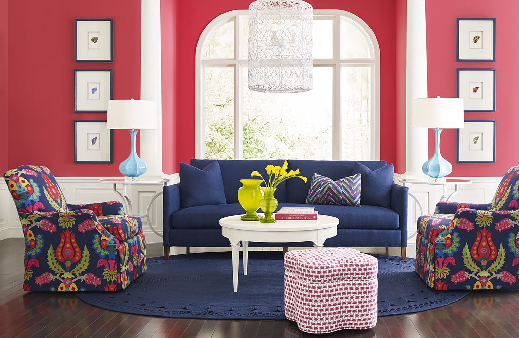 Deep shades of coral in this beautiful living room contrast with the navy sofa and rug.
