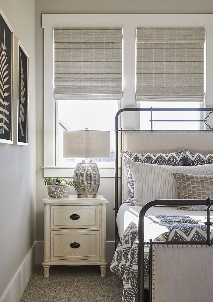 This guest bedroom is inviting for any visitor with custom shades for privacy.